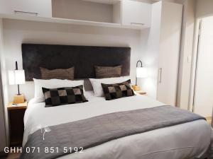 比勒陀利亚Regency Apartment的一间卧室配有一张大床和大床头板