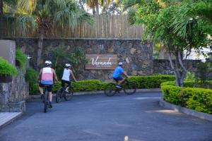 格兰高伯Veranda Paul et Virginie Hotel & Spa - Adults Only的三人骑着自行车沿着公园的小路骑行