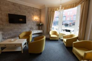 布莱克浦卡尔顿酒店的客厅配有黄色椅子和电视