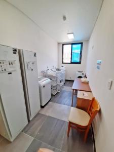 光阳Hotel Haemaru的客房设有带桌子和冰箱的厨房。