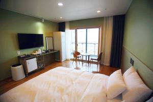 光阳Hotel Haemaru的一间卧室配有一张床和一张桌子及一台电视