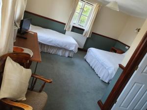 韦茅斯小帆船宾馆的酒店客房 - 带两张床、一张桌子和一把椅子