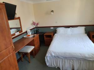 韦茅斯小帆船宾馆的酒店客房配有一张床和一张带电脑的书桌