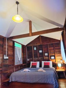 清刊พืชไทยเชียงคาน(Plantthai)的卧室配有一张床铺,位于带木墙的房间内