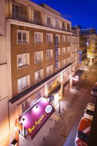 马德里格兰大街阿文尼达酒店的前面有紫色标志的建筑