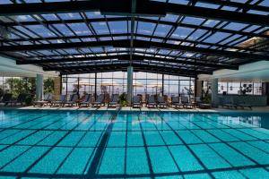 罗什平纳Mizpe Hayamim by Isrotel Exclusive的一座带椅子的大型游泳池和一座建筑