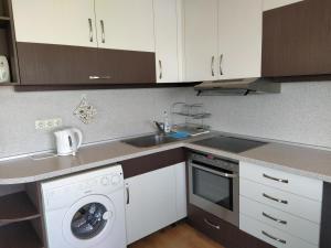 布尔加斯阳光金沙一室公寓酒店的厨房配有水槽和洗衣机