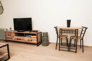 波德戈里察Studio Apartment Vukcevic的客厅配有电视和桌椅