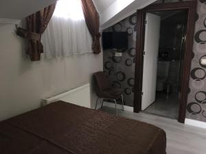 伊斯坦布尔Petrol-İş İstanbul Misafirhanesi的一间卧室配有一张床、一把椅子和镜子
