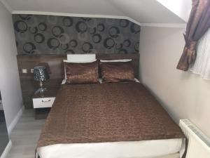 伊斯坦布尔Petrol-İş İstanbul Misafirhanesi的一间卧室配有一张带棕色棉被的床