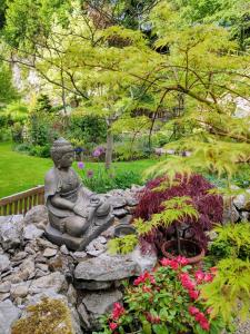 马特洛克瀑布花园住宿加早餐旅馆的坐在花园里的佛陀雕像