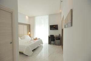 那不勒斯加里波第酒店的一间卧室配有一张床、一张书桌和一面镜子