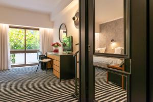 蒙特里尔D.阿方索Spa酒店的一间卧室配有一张床、一张书桌和一面镜子