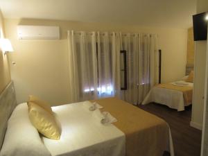 贝拉新镇Albergue El Encuentro的酒店客房,配有两张带白色床单的床