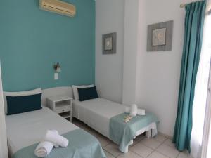伊奥斯乔拉Corali Hotel Beach Front Property的蓝色墙壁客房的两张床