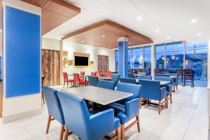 斯普林菲尔德Holiday Inn Express & Suites - Springfield North, an IHG Hotel的一间带桌子和蓝色椅子的用餐室