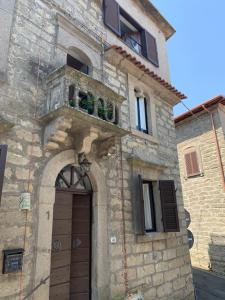 博马尔佐Casa di Giulietta的石头建筑,设有门和阳台