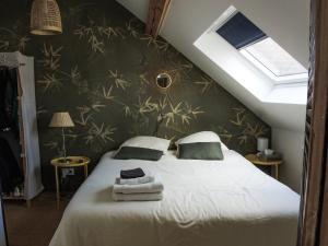 亚眠Les Chambres du Verger的一间卧室配有一张床,上面有两条毛巾