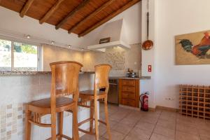 贝纳吉Villa Diane Luxury Cottage Ocean views pool的厨房配有2把木椅和桌子