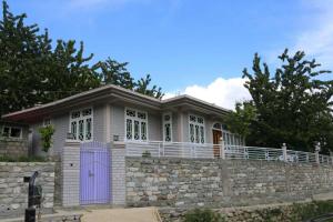 BaltitHunza Heaven Guest House的一座石墙和紫色门的房子