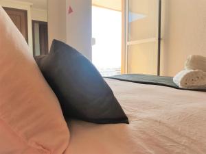 马雷尼布劳High-Floor Bright Apartment with Sea Views的床上的黑色枕头,有窗
