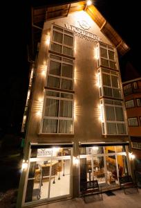 格拉玛多Micheline Hotel Tricot - ao lado da Rua Coberta的一座建筑,在晚上有灯