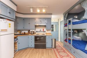 哥德伍德Alyeska Retreat C110的一间带蓝色橱柜和双层床的厨房