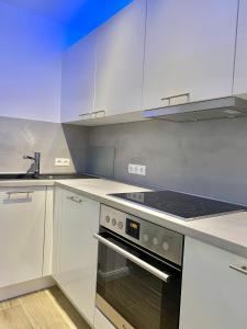 汉堡3-Raum Apartment Quartier57 Hamburg-Eppendorf的厨房配有白色橱柜和烤箱。