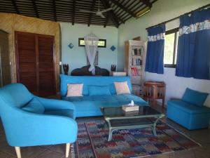 Opoa阿提亚皮逖酒店的客厅配有蓝色的沙发和两把椅子