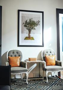 雅典Art Pantheon - Suites & Apartments的客厅配有两把椅子和一副树的照片
