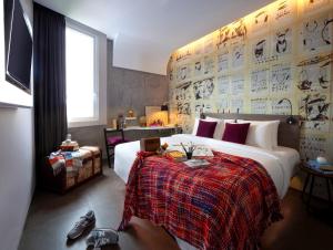 雅加达ARTOTEL Thamrin Jakarta的一间卧室配有一张带红色毯子的大床