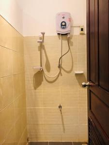 万象HideSeek Hostel Vientiane Thai embassy的墙上设有带吹风机和淋浴的浴室