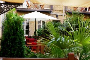柏林花园生活 - 精品酒店的一个带遮阳伞、椅子和植物的庭院