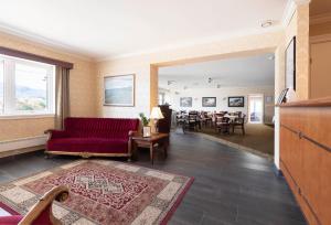 SykkylvenAursnes Hotell的客厅配有红色的沙发和桌子