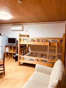 京都Ichijyo IVY 5 persons room的客房设有一张带沙发的双层床。