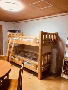 京都Ichijyo IVY 5 persons room的一张木制双层床,位于带桌子的房间