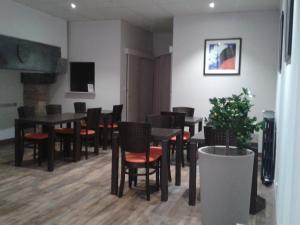 维特雷勒敏诺特尔酒店的用餐室配有黑色桌子和红色椅子