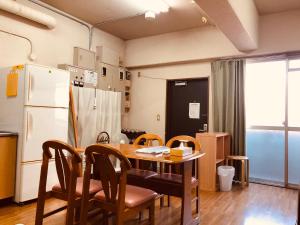 京都Nishijin IVY 5 persons room的厨房配有桌椅和冰箱。