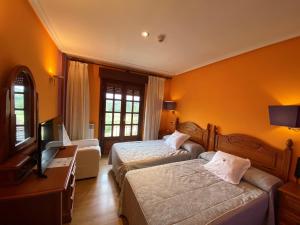 普韦布拉桑纳比亚提拉罗伯士酒店的酒店客房设有两张床和电视。