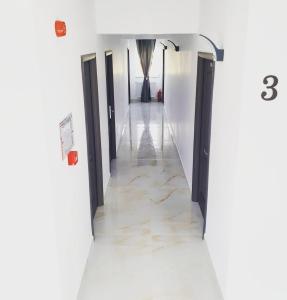 北马马亚-讷沃达里ZETH HOUSE的走廊设有黑色门和大理石地板