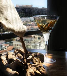 雅典雅典之A酒店的坐在窗边桌子上的一杯葡萄酒