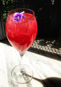 雅典雅典之A酒店的一杯红饮料,玻璃上装有紫色花