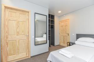 帕兰加Palanga Centrum的卧室配有白色的床和镜子