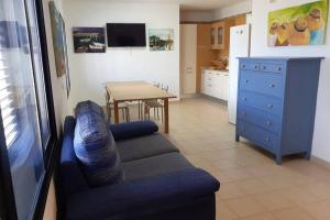 塞博河畔卡莱塔VILLA LA TEGALA的客厅配有蓝色的沙发和桌子