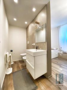 卡萨马西马L'ArChasetta Historic Apartments的白色的浴室设有水槽和卫生间。