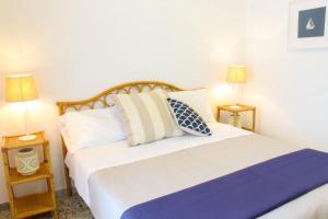 蓬扎Rosa Dei Venti Ponza的一间卧室配有一张带两盏灯的大型白色床。