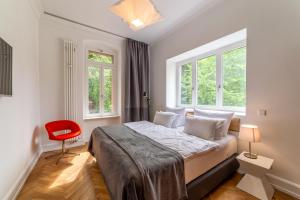 海德堡海德堡兹维特故乡酒店的一间卧室配有一张床和一张红色椅子