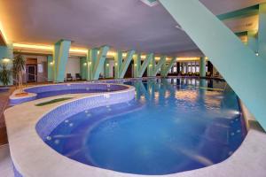 伯伊莱图什纳德丘卡什酒店的酒店大堂的大型游泳池