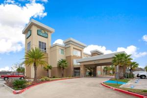 WestlakeLa Quinta by Wyndham Lake Charles - Westlake的停车场内棕榈树的酒店大楼