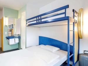 汉诺威汉诺威宜必思快捷酒店的一间卧室配有两张双层床和镜子